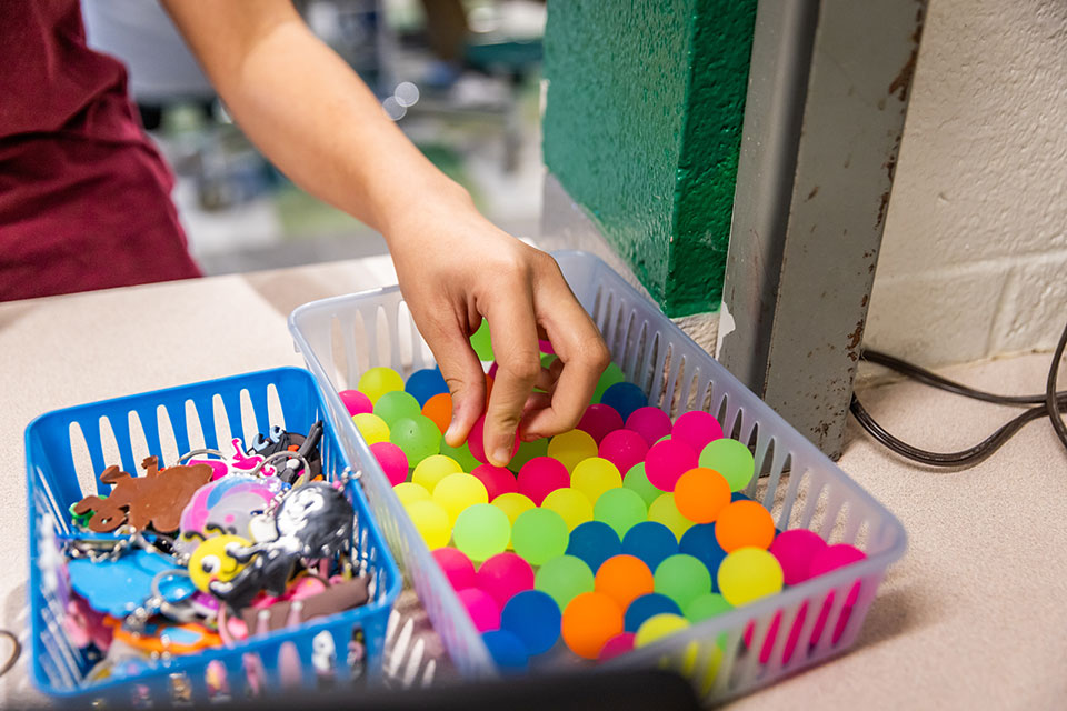 Plastic bins full of colorful keychains and bouncy balls