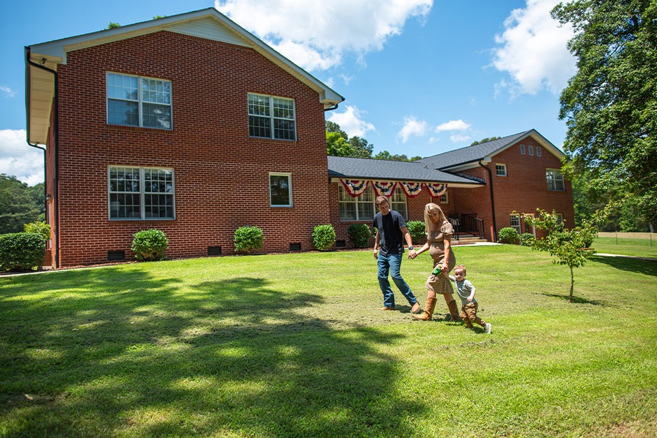 Family walk next to house financed through Rural 1st home loan in Tennessee.