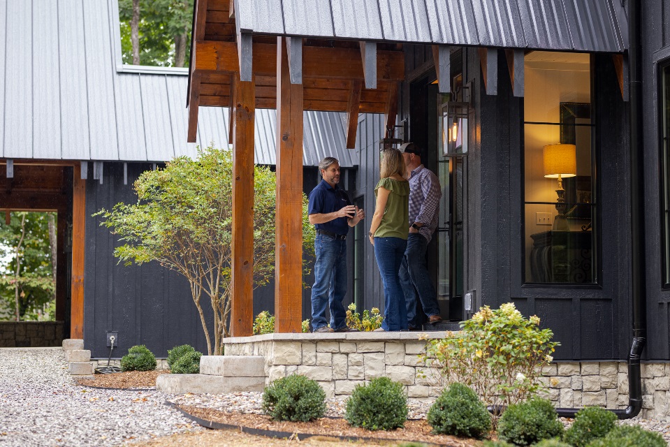 Man and woman meeting with a loan officer on the front porch