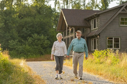 Couple walks past their new log home