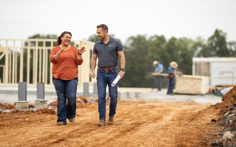 A Rural 1st loan officer with a client on the construction site of a rural home.