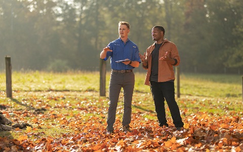 A Rural 1st loan officer chatting with a client in a rural field.