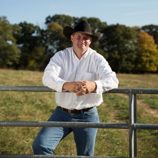 Man leans on a gate.